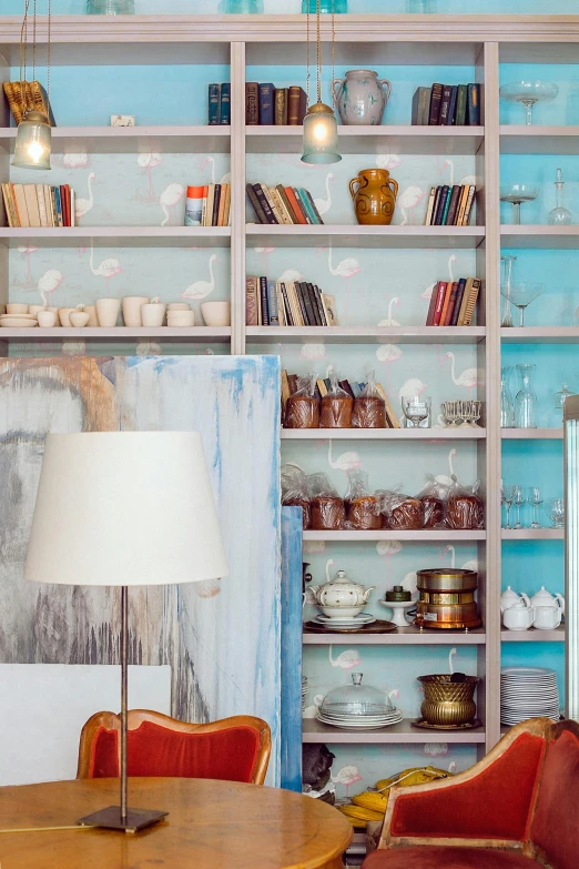 a room that has a table and chairs in it, a portrait, by Konrad Witz, trending on unsplash, maximalism, large sweet jars on shelves, pale blue backlight, chinoiserie wallpaper, bookshelf