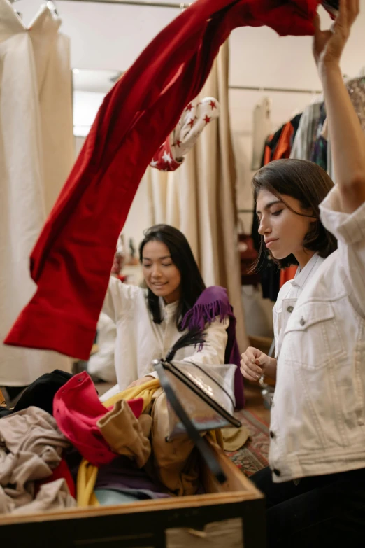 a group of women standing next to each other in a room, trending on pexels, happening, inspect in inventory image, red clothes, tattered clothes, woman holding another woman