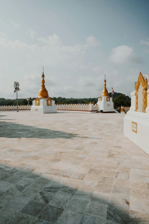 a group of white and gold statues in a courtyard, trending on unsplash, myanmar, panoramic view, rooftop, square