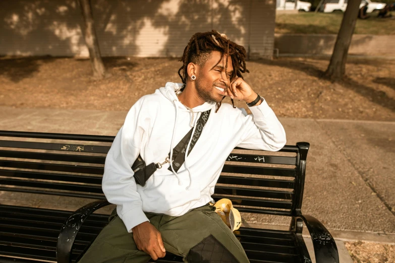 a man sitting on a bench talking on a cell phone, an album cover, trending on pexels, ashteroth, goofy smile, morning golden hour, street wears