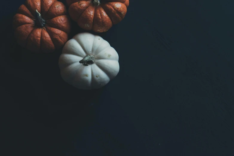 a group of small pumpkins sitting on top of a table, unsplash, ☁🌪🌙👩🏾, dark. no text, high resolution, limbs