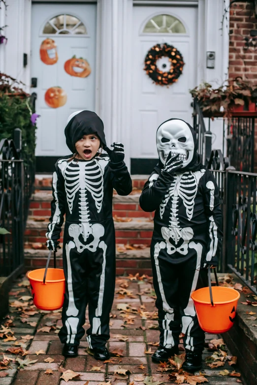 two children in skeleton costumes standing in front of a house, by Ellen Gallagher, pexels, snacks, exiting store, black, 256435456k film