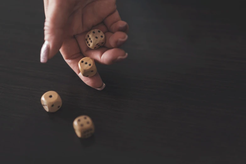 a person holding two dice on top of a table, brown holes, instagram picture, cinematic shot ar 9:16 -n 6 -g, threes