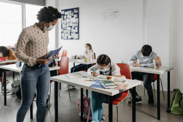 a group of children sitting at desks in a classroom, a child's drawing, by Lee Loughridge, pexels contest winner, people are wearing masks, writing on a clipboard, te pae, standing on a desk