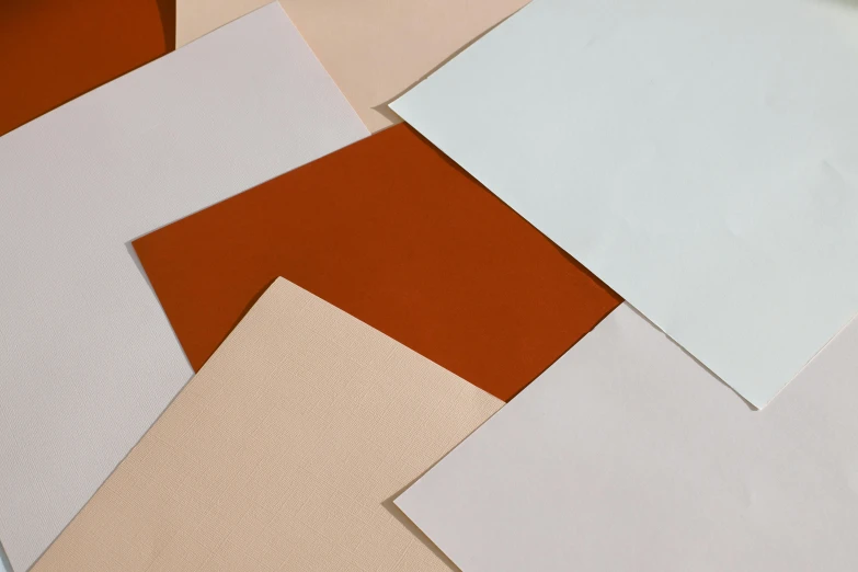 a bunch of papers sitting on top of a table, inspired by Frederick Hammersley, color field, terracotta, monochrome, smooth details, lacquered