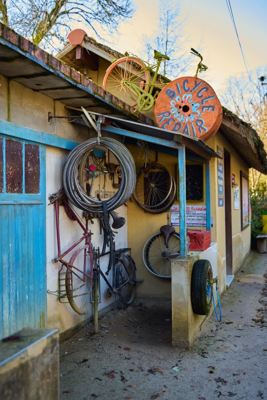 a bicycle shop on the side of a road, art nouveau, st cirq lapopie, fan favorite, earthship, hoses