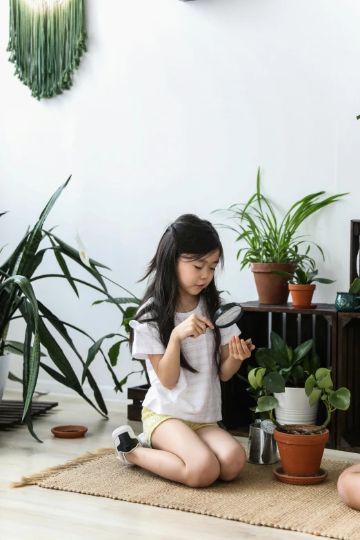 a couple of women sitting next to each other on the floor, a picture, inspired by Yeong-Hao Han, pexels contest winner, process art, pots with plants, little girl, panoramic centered view of girl, singapore