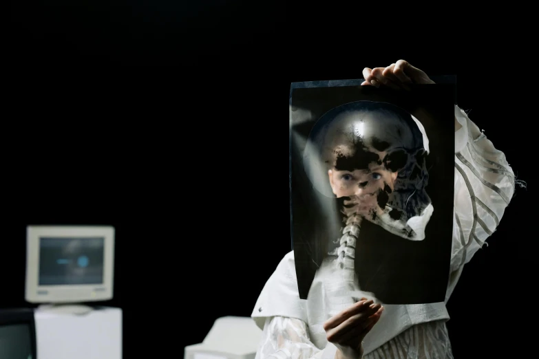 a person holding up a picture of a cat, a hologram, inspired by Anna Füssli, unsplash, hyperrealism, skull in broken space helmet, nadav kander, still image from tv series, medical image