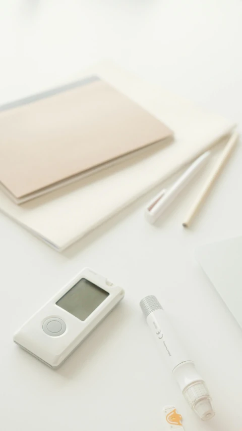 a laptop computer sitting on top of a white desk, by Awataguchi Takamitsu, unsplash, medical supplies, cream and white color scheme, pencil, wooden casing