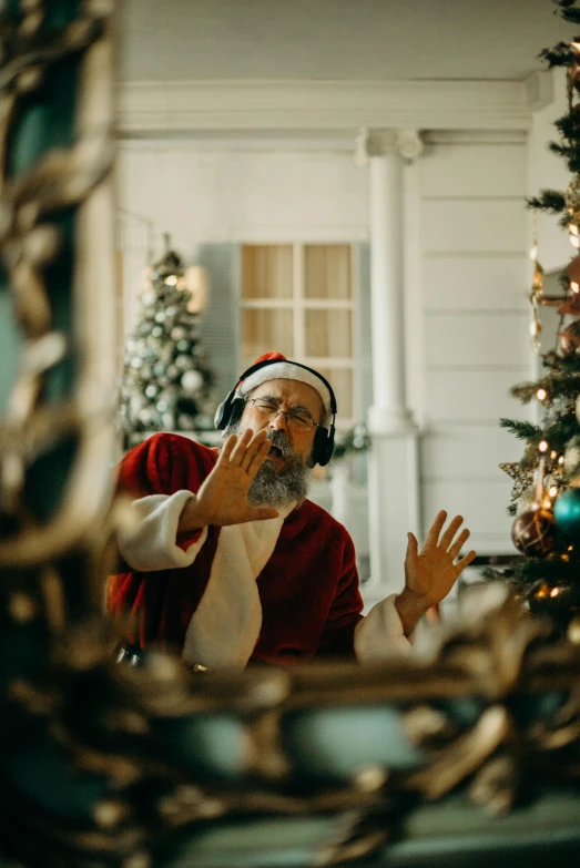 a man in a santa suit standing in front of a christmas tree, pexels contest winner, happening, vibing to music, looking in mirror at older self, movie scene, ( ( theatrical ) )