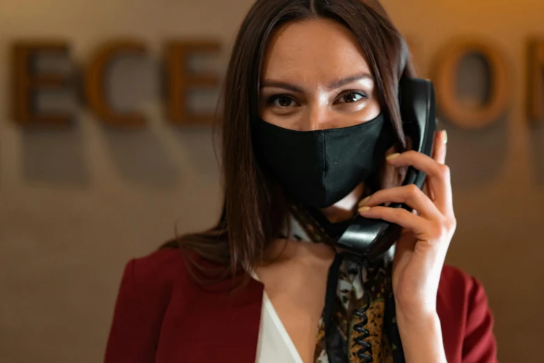 a woman wearing a mask talking on a cell phone, pexels contest winner, private press, elegantly dressed, cowl, worksafe. instagram photo, hotel room