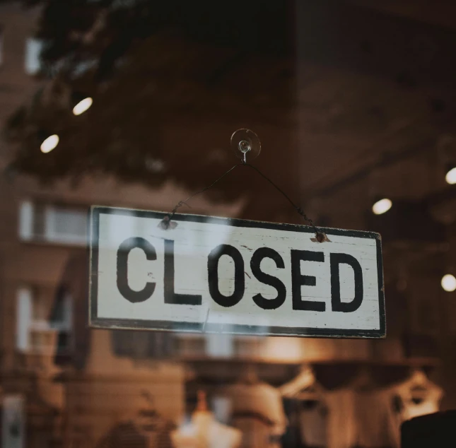 a close up of a closed sign in a window, unsplash, shops, background image, lacquered, closed hands