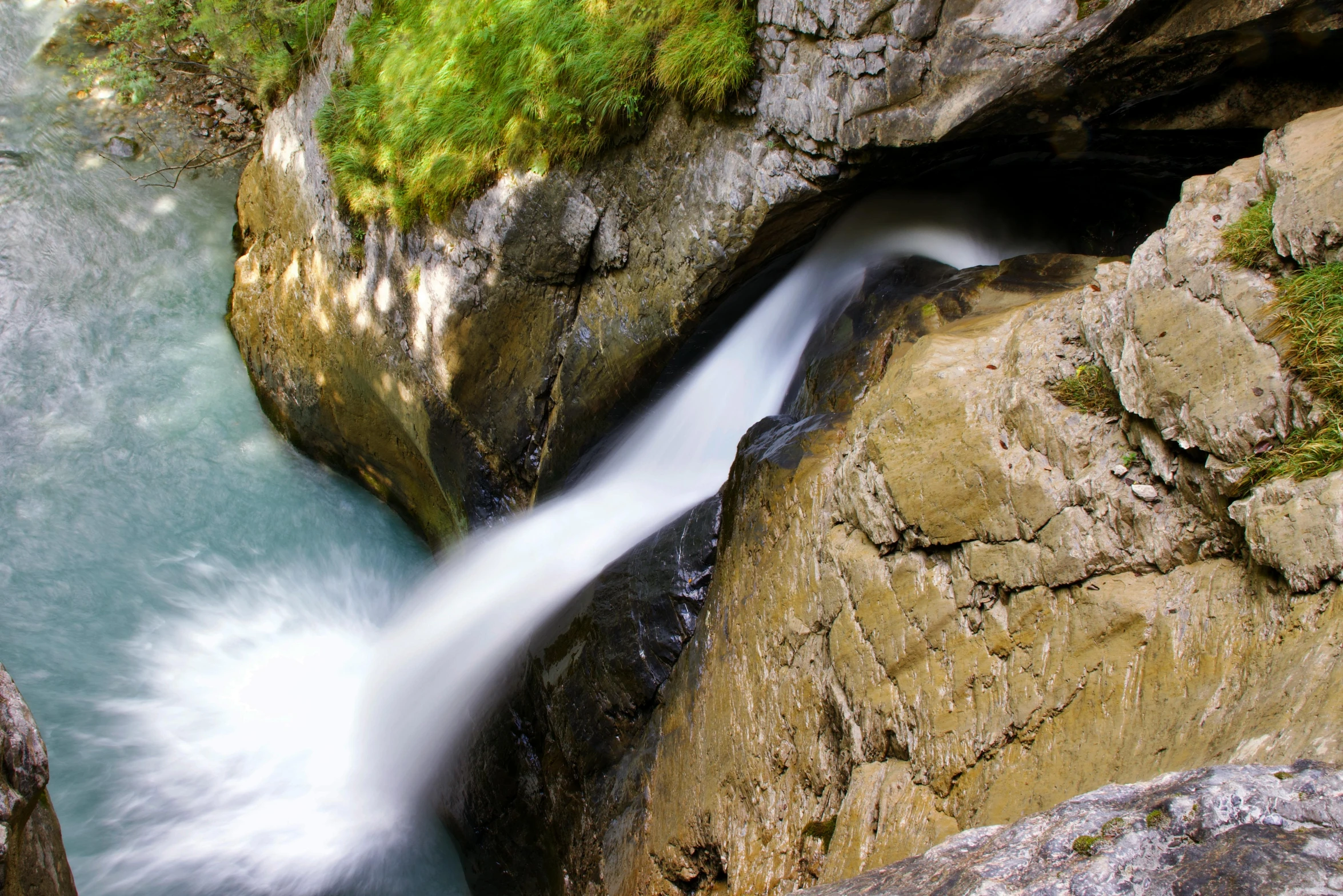 a river running through a lush green forest, an album cover, by Franz Hegi, pexels contest winner, hurufiyya, rocks falling, inside a gorge, thumbnail, grey