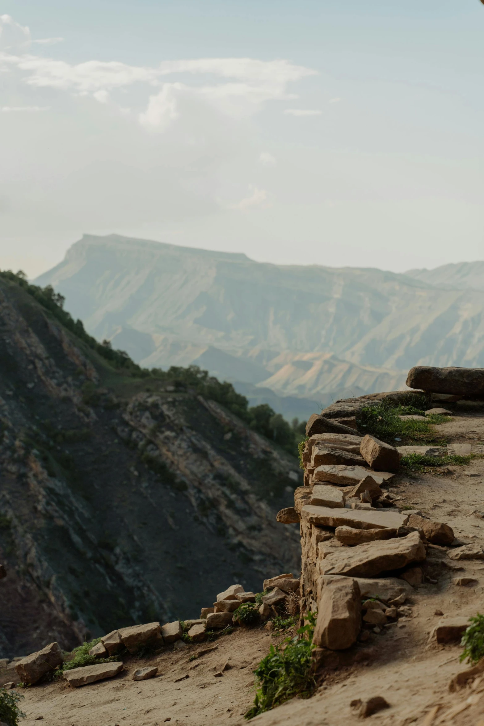 a man sitting on top of a rock on top of a mountain, les nabis, seen from afar, jagged blocks of stone, vastayan, zoomed out