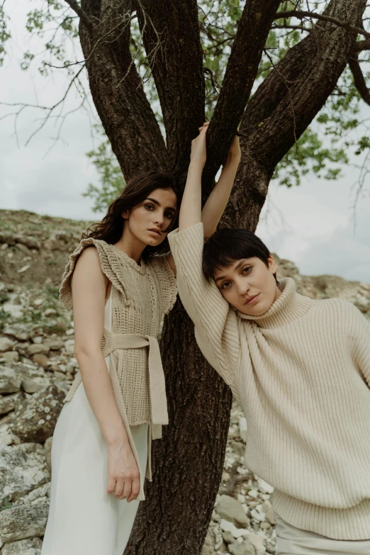 a man and a woman leaning against a tree, trending on pexels, renaissance, fashion editorial, two women, muted brown, off - white collection