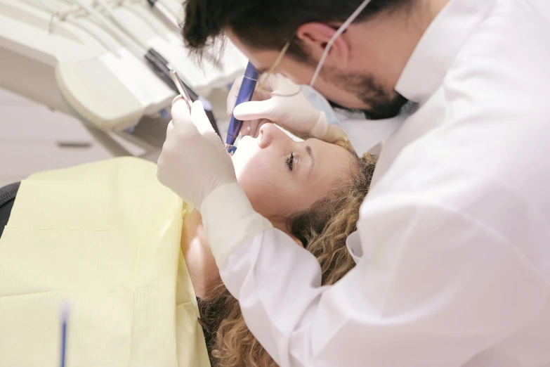 a woman getting her teeth examined by a dentist, pexels contest winner, happening, caring fatherly wide forehead, youtube thumbnail, on an operating table, profile image