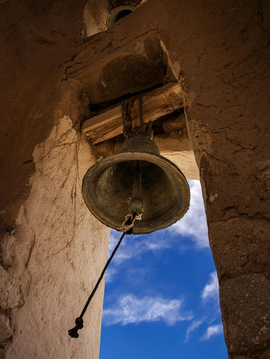 a bell hanging from the side of a building, ancient ruins under the desert, looking up into the sky, 2019 trending photo