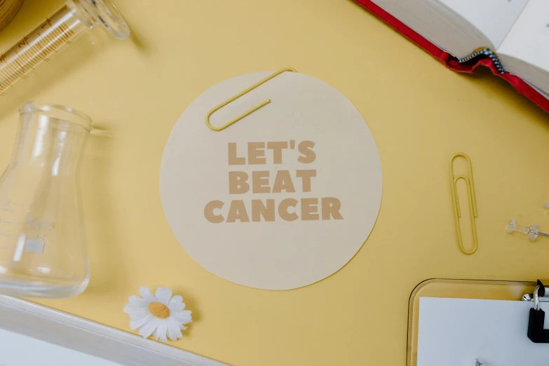 there is a sticker that says let's beat cancer, by Julia Pishtar, happening, beige, uk, light yellow, high-quality photo