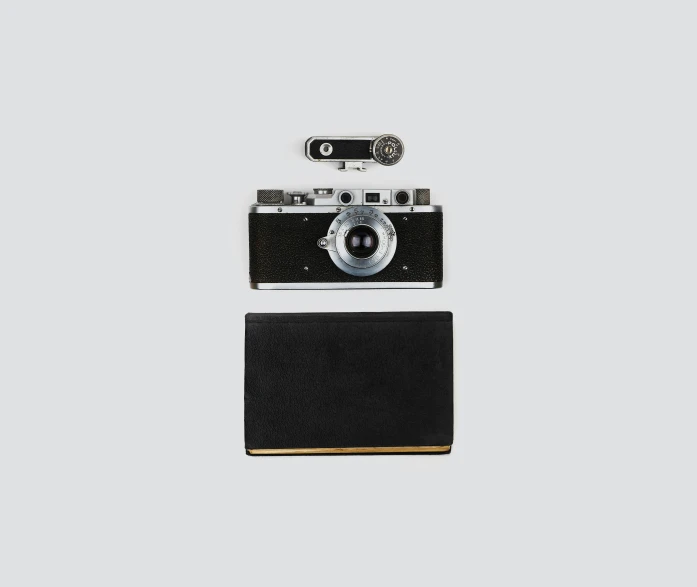 a black and white photo of a camera, a picture, by Andries Stock, unsplash contest winner, minimalism, gold and black color scheme, vintage - w 1 0 2 4, miniature product photo, rectangular