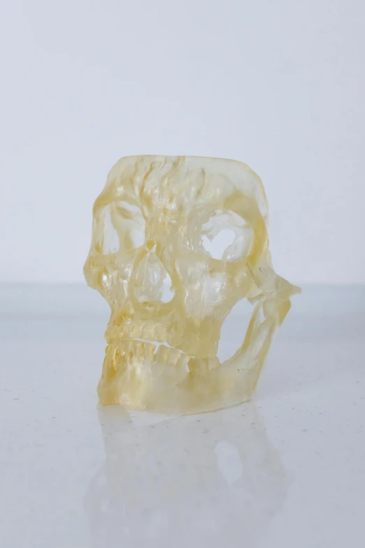 a carved skull sitting on top of a table, yellow translucent lace, 1 / 8 0 s, 3 d print, open synthetic maw