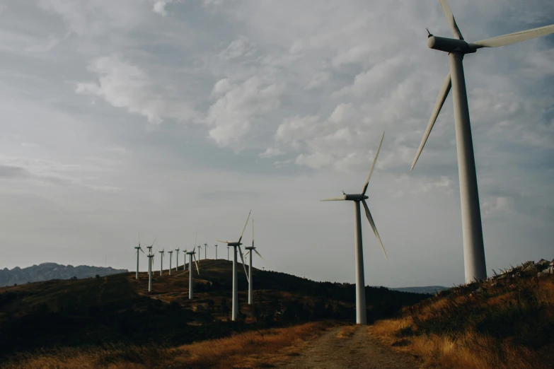 a group of wind turbines sitting on top of a hill, pexels contest winner, grey, **cinematic, profile image, thumbnail