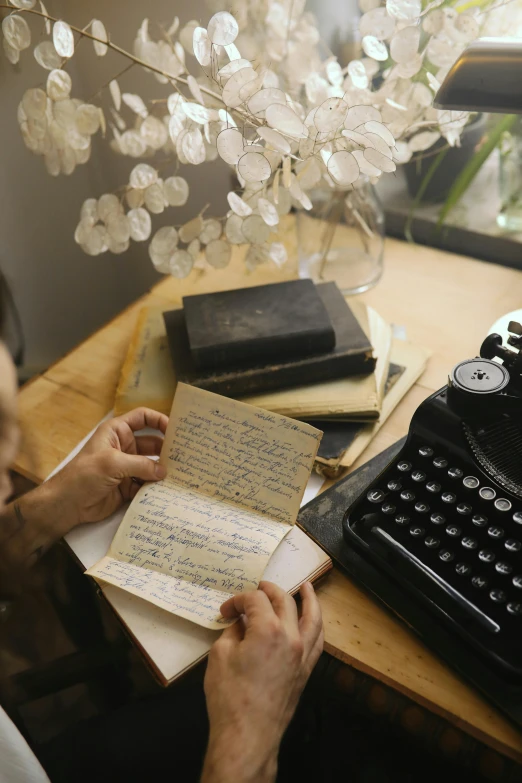 a person sitting at a desk with a typewriter, an album cover, by Jessie Algie, unsplash, romanticism, holding notebook, thumbnail, multiple stories, to