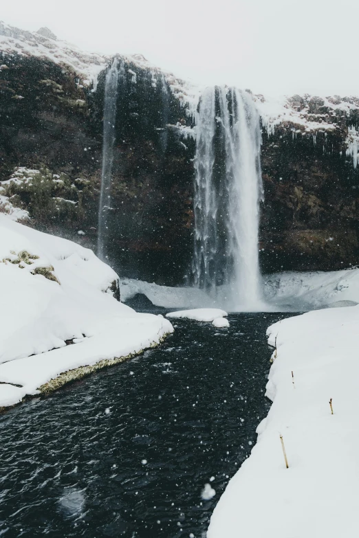 a person standing in front of a waterfall in the snow, hurufiyya, background image