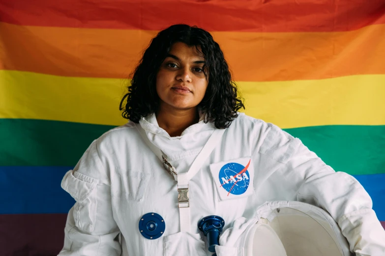 a woman standing in front of a rainbow flag, wearing astronaut outfit, ash thorp khyzyl saleem, jayison devadas, sitting on a moon