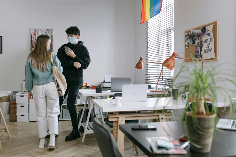 a couple of people that are standing in a room, trending on pexels, arbeitsrat für kunst, home office, wearing mask, ad image, desks