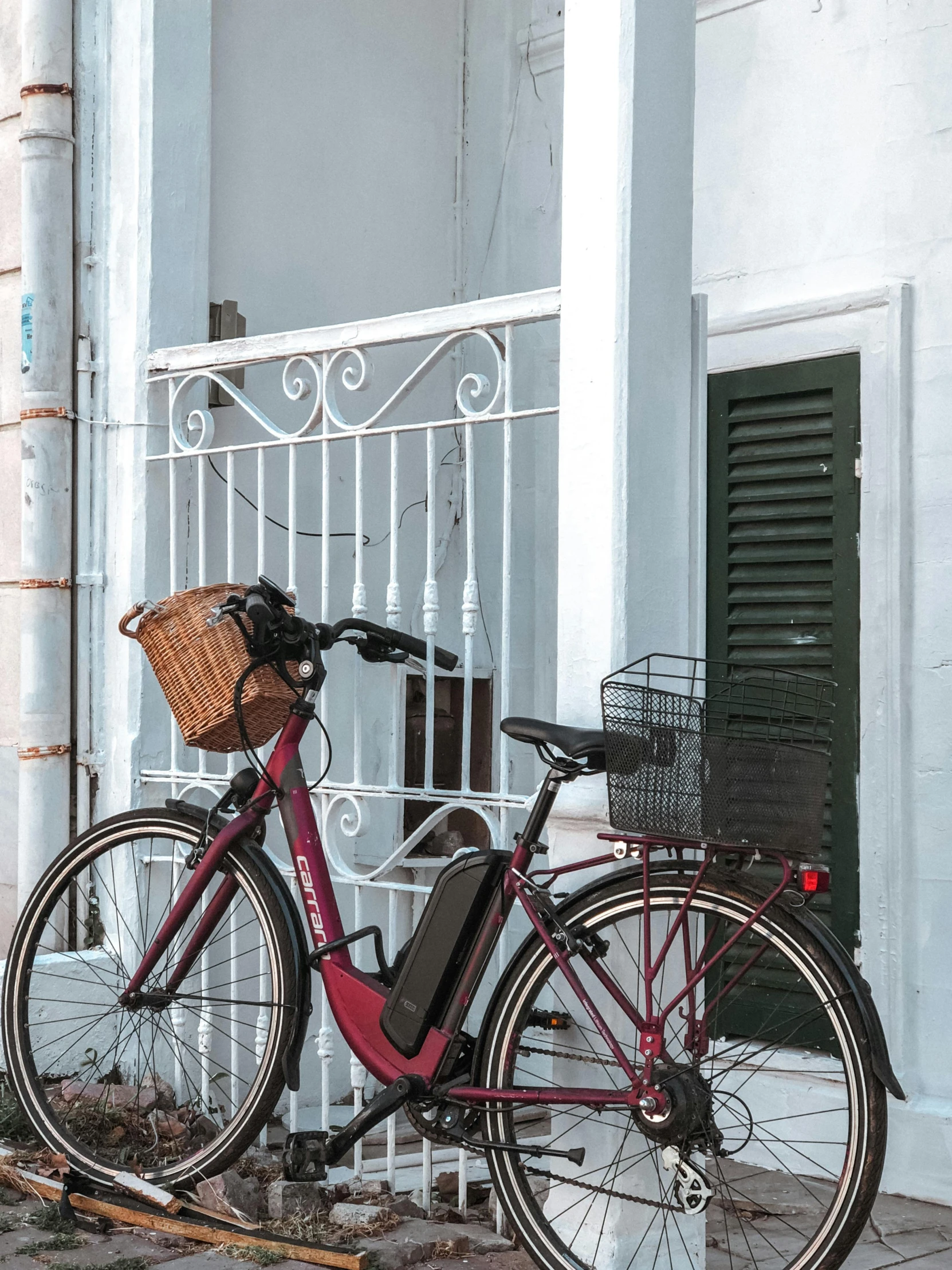 a bicycle parked in front of a building, viridian and venetian red, electrical details, wine red trim, al fresco