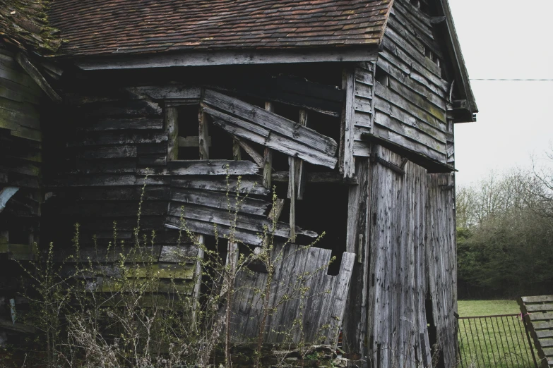 an old wooden building sitting in the middle of a field, unsplash, renaissance, broken down grey wall, background image, inside a shed, collapsed floors