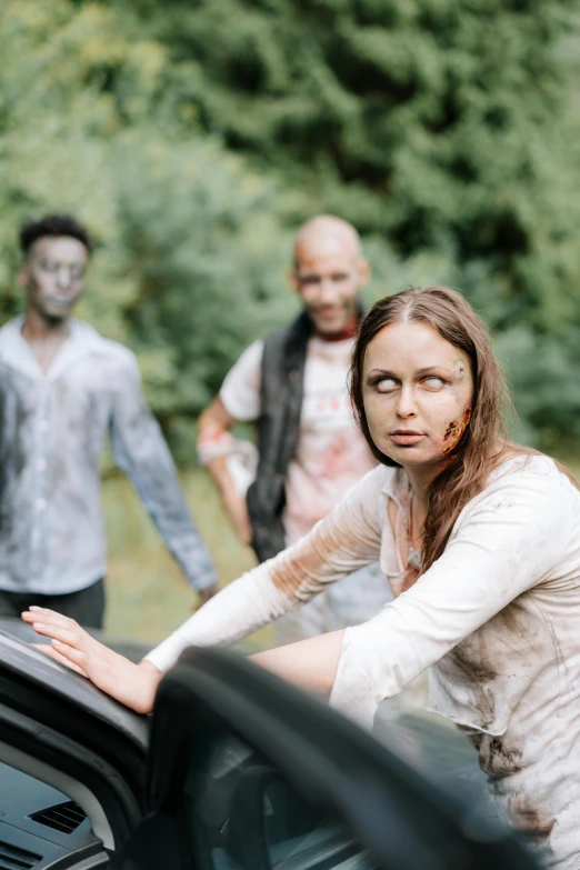 a group of people that are standing next to a car, zombie face, sitting down