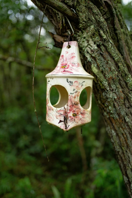 a birdhouse hanging from a tree in the woods, inspired by Annabel Kidston, ceramics, almond blossom, hero shot, dim lantern