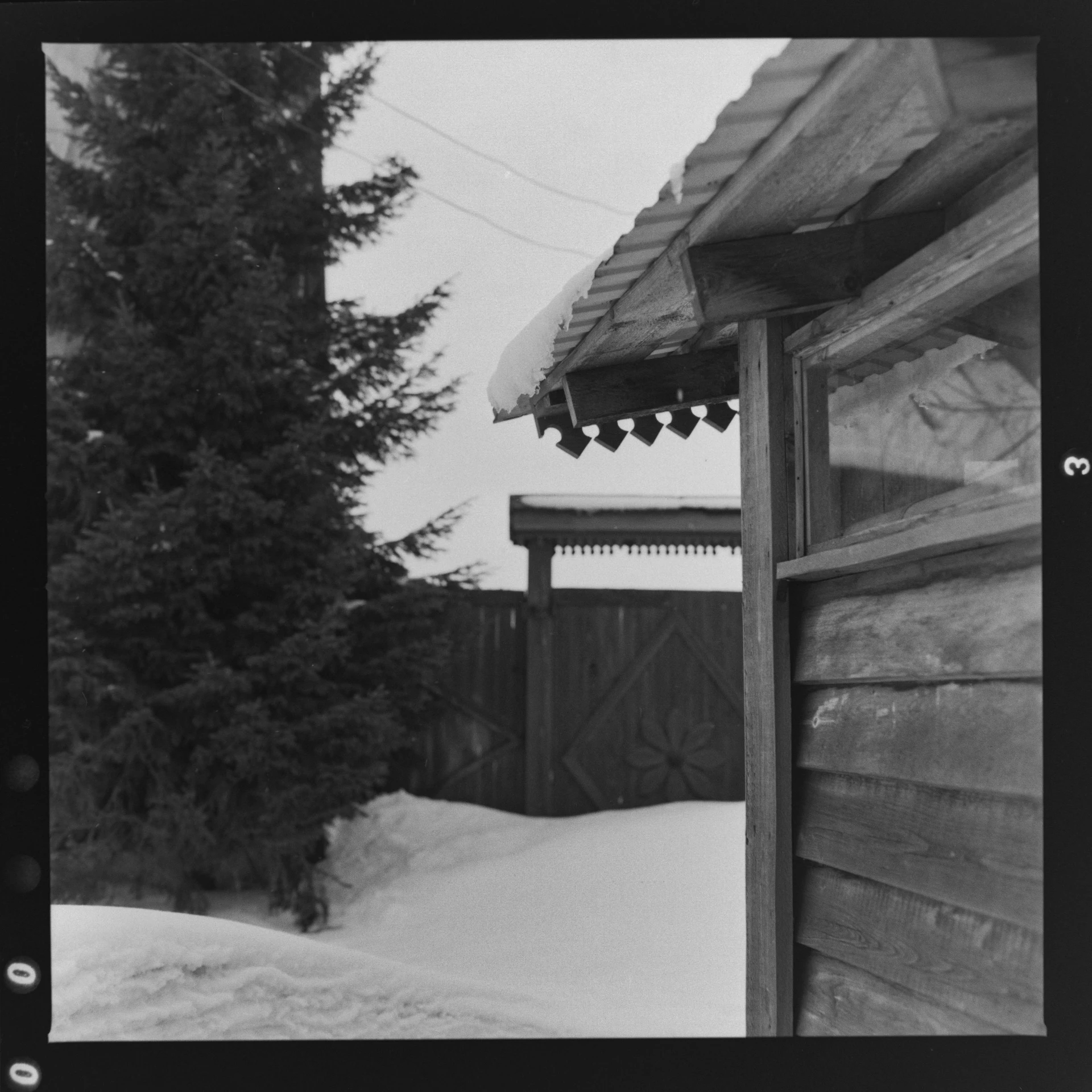 a black and white photo of a cabin in the snow, a black and white photo, by Maurycy Gottlieb, flickr, folk art, looking around a corner, 3 5 mm slide, bells, photo courtesy museum of art