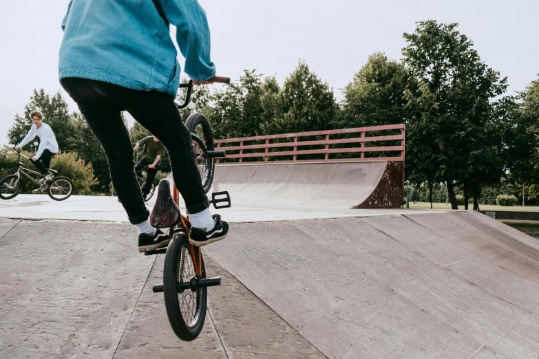 a person riding a bike up the side of a ramp, inspired by Seb McKinnon, pexels contest winner, at a park, at a skate park, 15081959 21121991 01012000 4k, panels