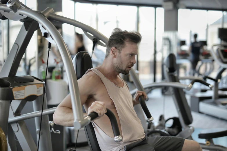 a man sitting on top of a machine in a gym, pexels contest winner, renaissance, head and chest only, lachlan bailey, face and shoulders focus, no - text no - logo