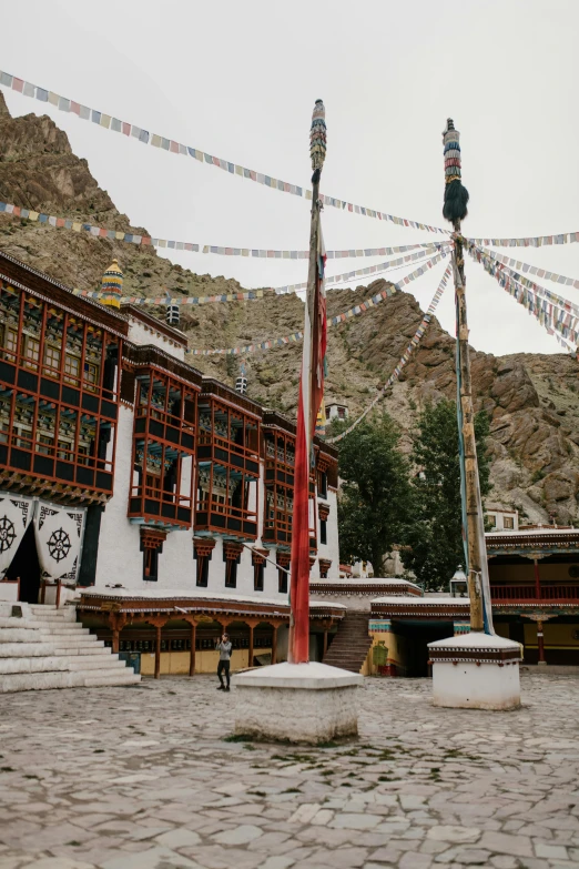 a group of people standing in front of a building, inspired by Lü Ji, trending on unsplash, hurufiyya, tibet, tapestries hanging from ceiling, exterior wide shot, orthodox