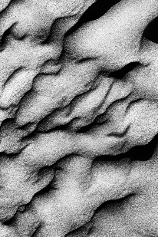 a black and white photo of some snow, inspired by Edward Weston, featured on zbrush central, generative art, sandstone, stone relief, abstract claymation, lumpy skin