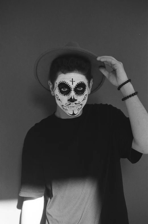 a black and white photo of a man wearing a sugar skull mask, by Izzy Medrano, declan mckenna, sombrero, yung lean, mime