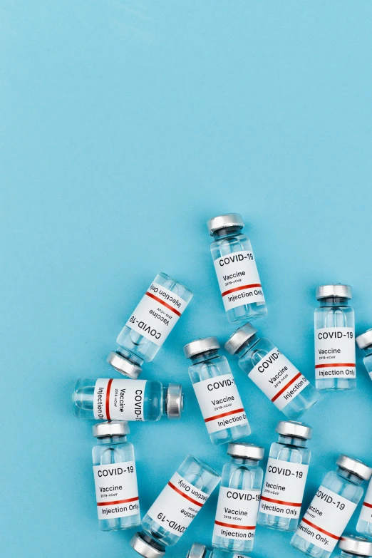 a bunch of vials sitting on top of a blue surface, thumbnail, medical labels, covid, 1x