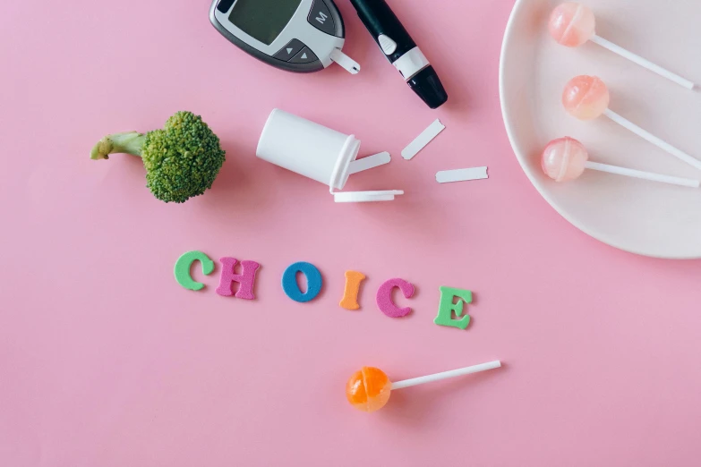a white plate topped with lollipops on top of a pink surface, a picture, trending on pexels, colorful medical equipment, lettering, laica chrose, veggies