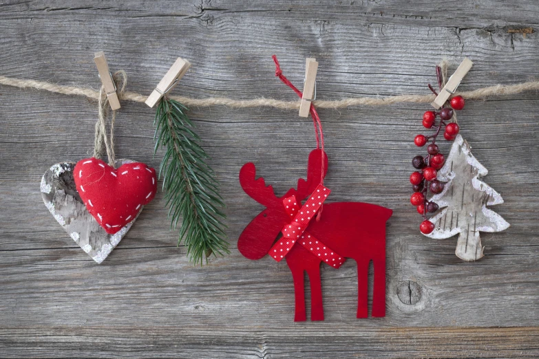 christmas decorations hanging from clothes pegs on a rope, pexels contest winner, folk art, crimson accents, deers, red hearts, pine