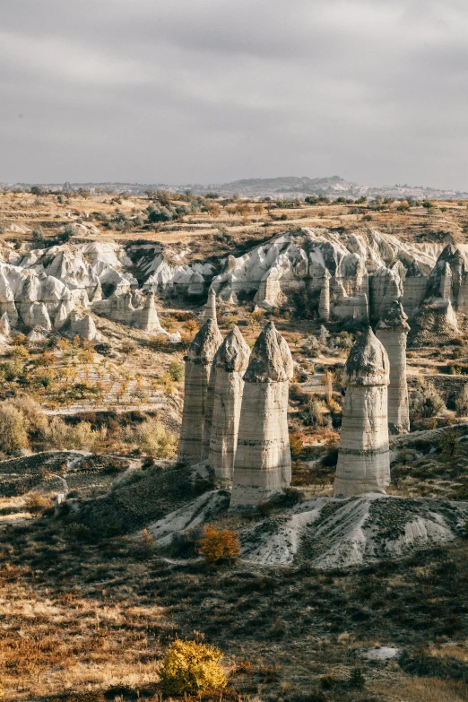 a rock formation in the middle of a desert, inspired by Jan Kupecký, unsplash contest winner, art nouveau, tall stone spires, turkey, wide high angle view, autumn