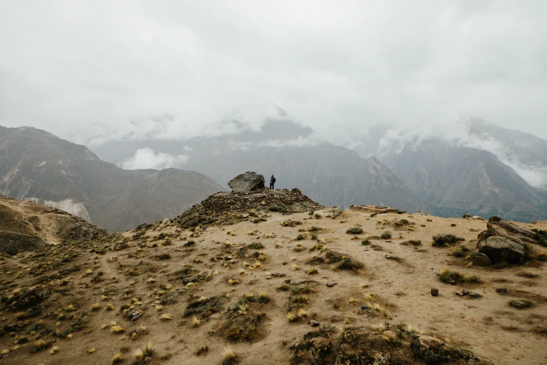 two people sitting on top of a mountain, trending on unsplash, peru, background image, overcast weather, pov photo