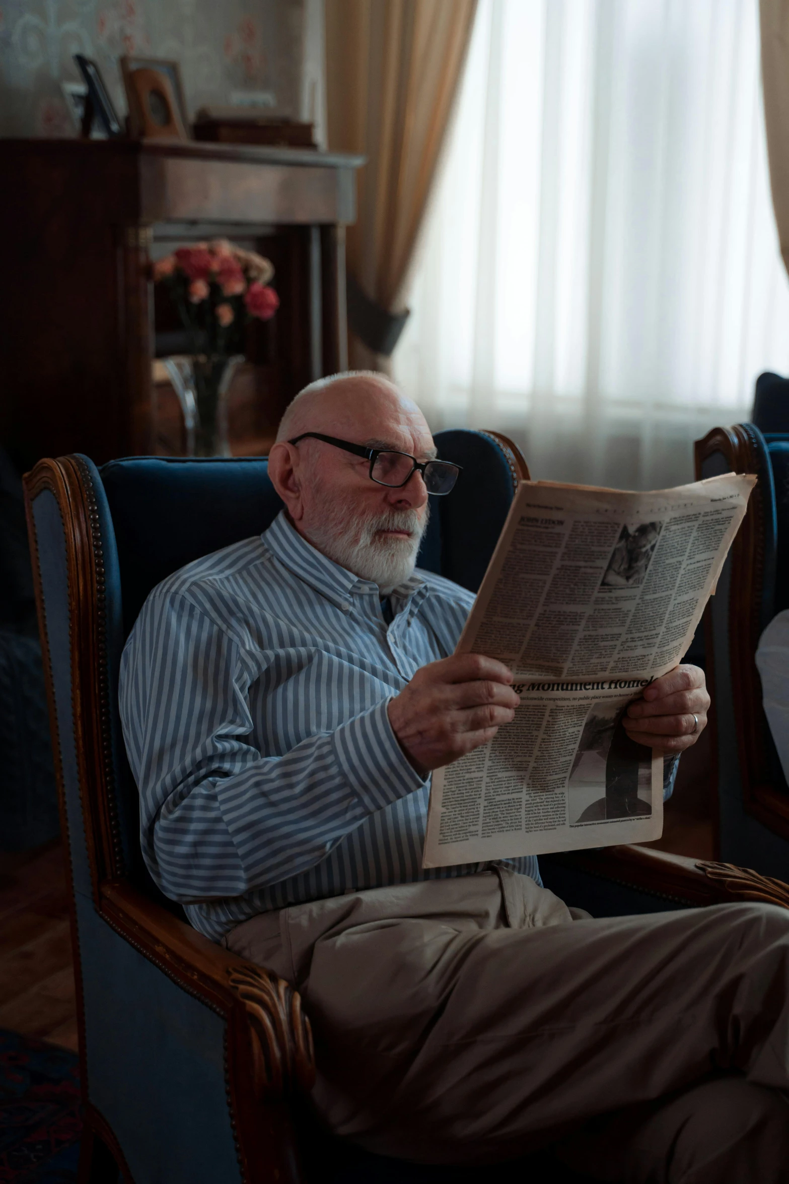 a man sitting in a chair reading a newspaper, trending on reddit, photorealism, white beard, shot from cinematic, inside a grand, wearing reading glasses