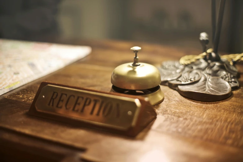 a hotel bell sitting on top of a wooden table, a room