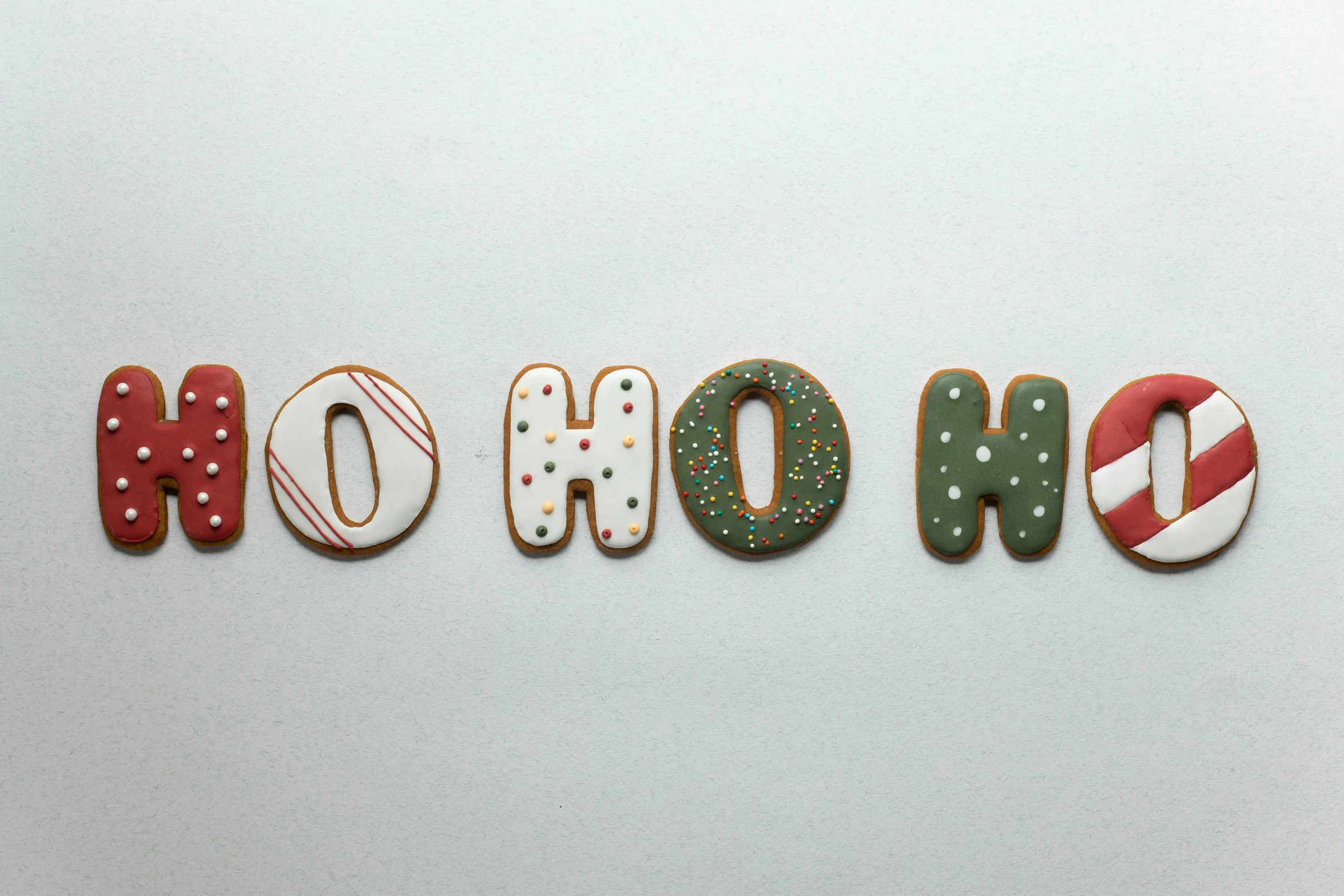 the word ho hoo spelled in cookies on a white surface, by Emma Andijewska, pexels, graffiti, santa, thumbnail, holo, david normal