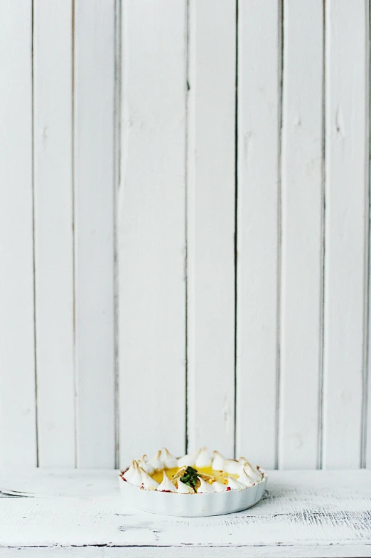 a bowl of food sitting on top of a wooden table, a picture, white picket fence, background image, silver，ivory, studio product shot