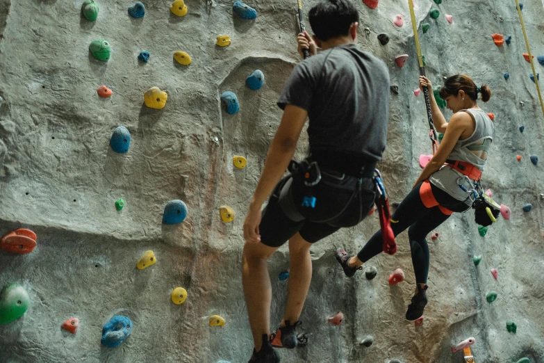 a man and a woman climbing on a rock wall, trending on pexels, biodome, manuka, dim dingy gym, thumbnail