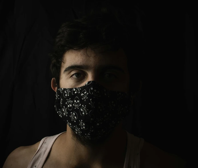 a man wearing a face mask in the dark, by Alejandro Obregón, lgbtq, dark glitter, official product photo, young man